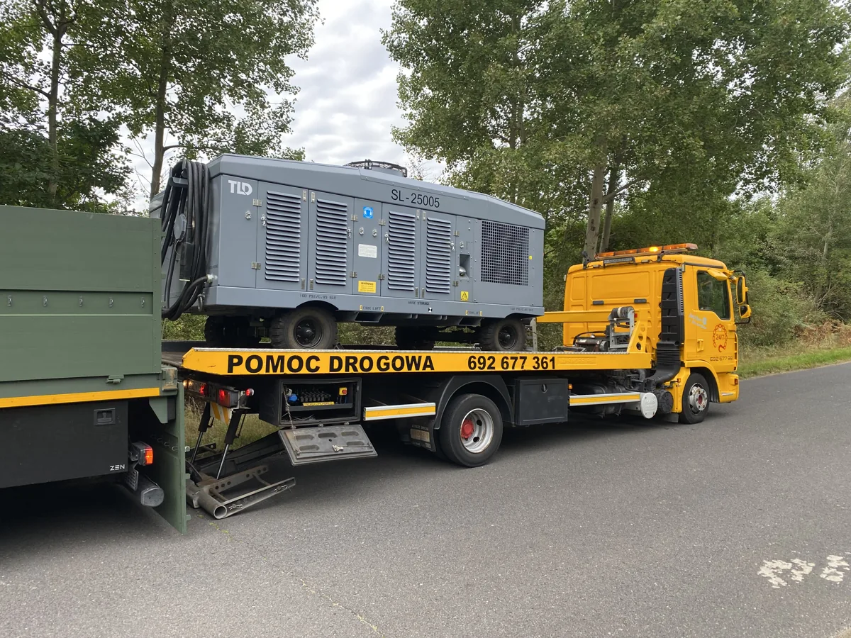 Żółty MAN TOPHOL z agregatem na platformie
